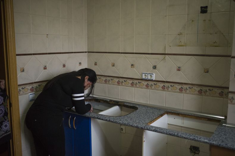 Carolina Salazar cubre su cara luego de que sus pertenencias han sido removidas de la casa de la cual fue expulsada en Madrid el jueves 27 de febrero de 2014. (Foto de AP/Andres Kudacki)