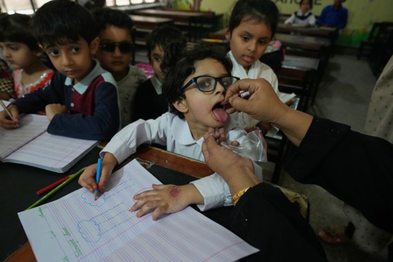 Una trabajadora de salud administra una vacuna contra la polio a un niño en una escuela en Lahore, Pakistán, el lunes de 13 de abril de 2026. (AP Foto/K.M. Chaudary)