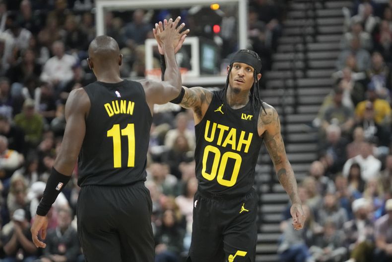 Jordan Clarkson (00) del Utah Jazz y Kris Dunn (11) celebran durante la primera mitad del juego de la NBA ante Los Ángeles Clippers, en Salt Lake City, Utah, el viernes 27 de octubre de 2023. (AP Foto/Rick Bowmer)