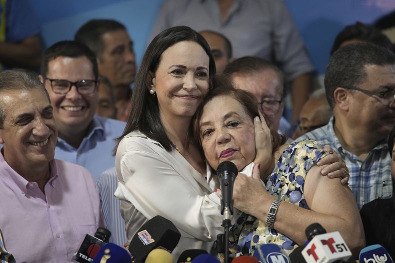 La líder opositora venezolana María Corina Machado abraza a Corina Yoris en conferencia de prensa, en Caracas, Venezuela, el viernes 22 de marzo de 2024. Machado nombró a Yoris como su sustituta para la contienda presidencial y se comprometió a luchar contra su inhabilitación política. (AP Foto/Ariana Cubillos)