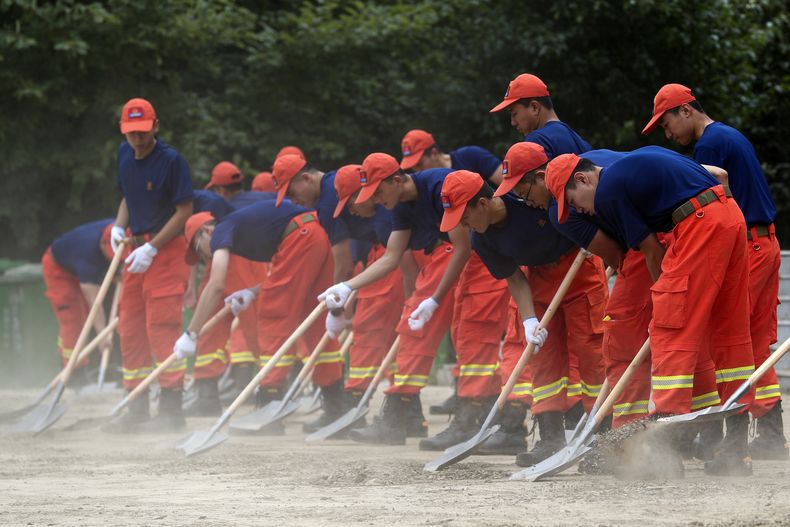 En esta foto distribuida por la Agencia Noticiosa Xinhua, bomberos abren una calle inundada por el desborde de un río en Ciudad Shangzi, provincia de Heilongjiang, noreste de China, 11 de agosto de 2023. (Zhang Tao/Xinhua via AP)