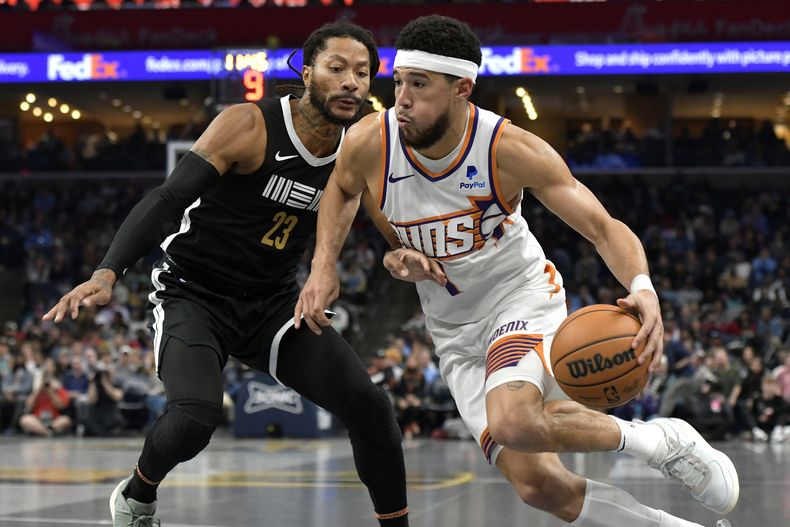 Devin Booker, de los Suns de Phoenix, avanza frente a Derrick Rose, de los Grizzlies de Memphis, en un encuentro del torneo In-Season, disputado el viernes 24 de noviembre de 2023 (AP Foto/Brandon Dill)