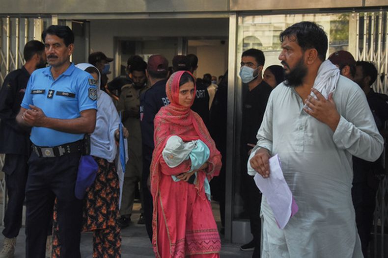 Una mujer lleva a su bebé en brazos al salir de una guardería en la sala de ginecología de un hospital tras un incendio, en Islamabad, Pakistán, el miércoles 26 de agosto de 2026. (Foto AP)