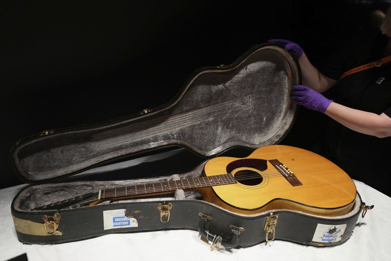 La guitarra acústica Harptone de 12 cuerdas y el estuche, utilizados por David Bowie en Ziggy Stardust and the Spiders from Mars y Lets Dance en 1970, se exhiben durante una vista previa de prensa en el Centro David Bowie, un nuevo archivo en la Bodega Este del Museo V&A en Londres, el miércoles 10 de septiembre de 2025, antes de su apertura al público el sábado. (Foto AP/Joanna Chan)