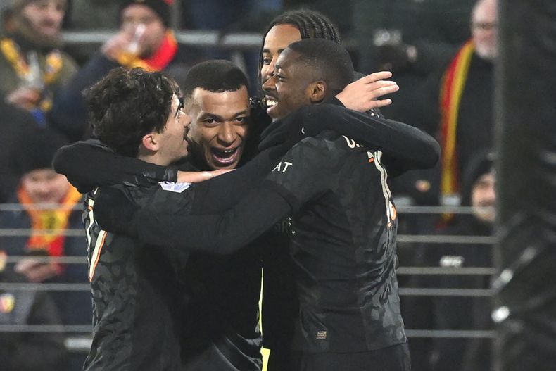 Jugadores de Paris Saint Germain celebran después de que Bradley Barcola anotara el primer gol de su equipo en el partido de la Liga 1 de Francia entre Lens y Paris Saint-Germain en el estadio Bollaert-Delelis en Lens, al norte de Francia, el domingo 14 de enero de 2024. (AP Foto/ Matthieu Mirville)