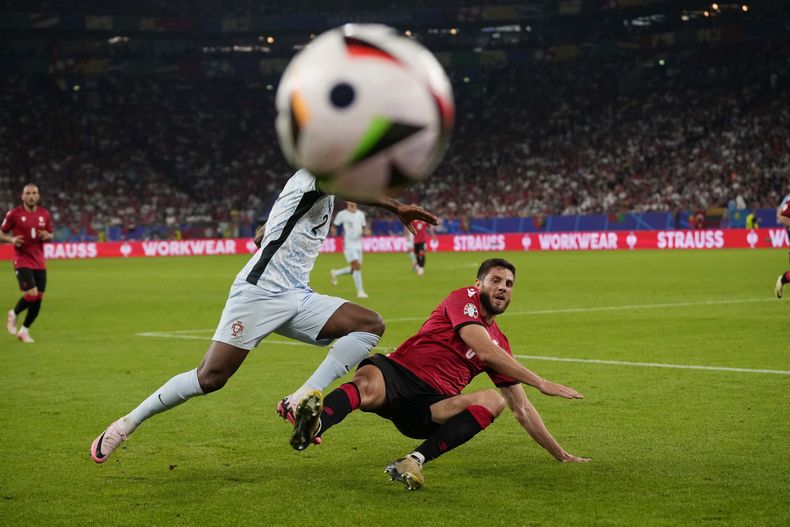 El portugués Nelson Semedo (izquierda) es derribado por el georgiano Lasha Dvali durante un encuentro de la Eurocopa disputado el miércoles 26 de junio de 2024, en Gelsenkirchen, Alemania (AP Foto/Alessandra Tarantino)
