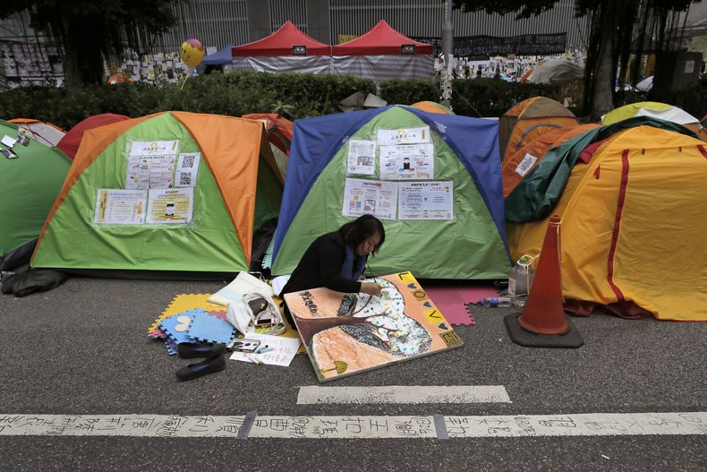 Un manifestante prodemocracia realiza un dibujo en una zona ocupada fuera de la sede del gobierno, en el distrito Admiralty de Hong Kong, el 13 de noviembre de 2014. (Foto AP/Vincent Yu)