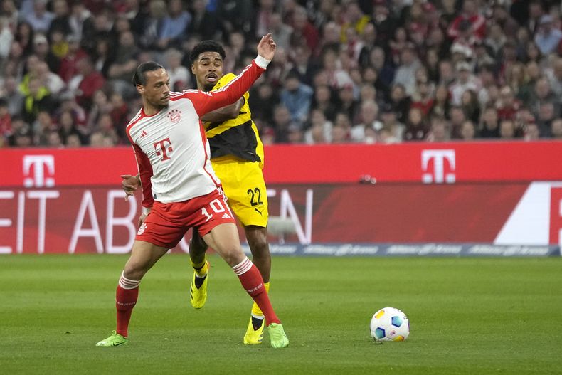 Leroy Sané del Bayern Munich pelea por el balón con Ian Maatsen del Borussia Dortmund en encuentro de la Bundesliga del sábado 30 de marzo del 2024. (AP Foto/Matthias Schrader)