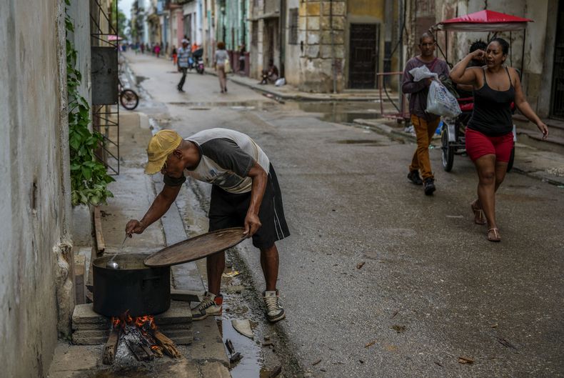 Un residente prepara una sopa sobre una hoguera durante un apagón masivo tras la falla de una importante planta eléctrica en La Habana, Cuba, el sábado 19 de octubre de 2024. (Foto AP/Ramón Espinosa)