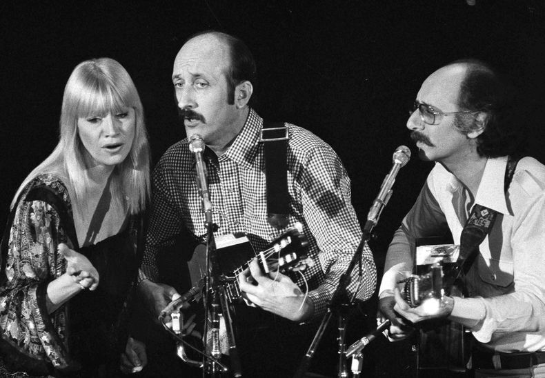 ARCHIVO - El trío folk Peter, Paul y Mary, desde la izquierda, Mary Travers, Paul Stookey y Peter Yarrow, actúan en un evento benéfico en Los Ángeles para ayudar a los refugiados camboyanos el 30 de enero de 1980. (Foto AP/George Brich, archivo)