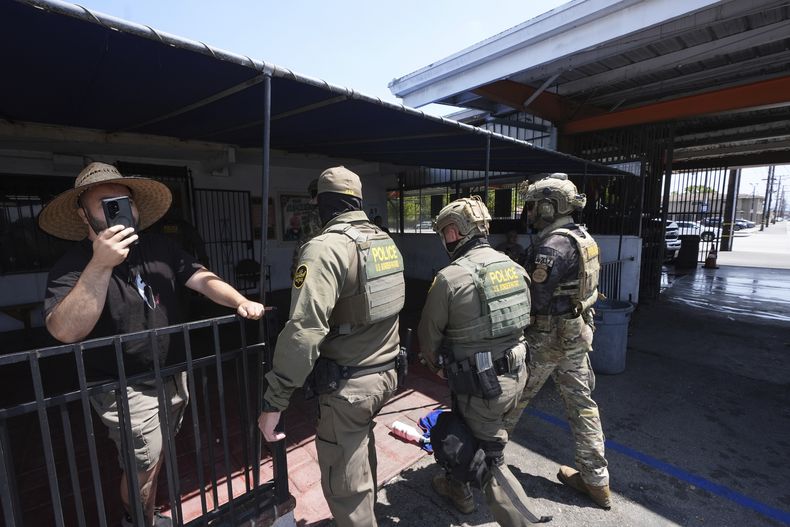 Agentes de inmigración llevan a cabo un operativo en un lavado de autos el viernes 15 de agosto de 2025 en Montebello, California. (AP Foto/Gregory Bull)