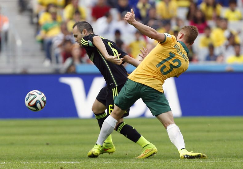 Andr&eacute;s Iniesta, de Espa&ntilde;a, elude a Oliver Bozanic, de Australia, durante el partido del Mundial entre ambas selecciones, el lunes 23 de junio de 2014, en Curitiba, Brasil (AP Foto/Jon Super)