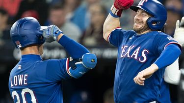Nathaniel Lowe, de los Rangers de Texas, festeja con Robbie Grossman su jonrón de tres carreras en el juego del miércoles 13 de septiembre de 2023, ante los Azulejos de Toronto (Spencer Colby/The Canadian Press via AP)