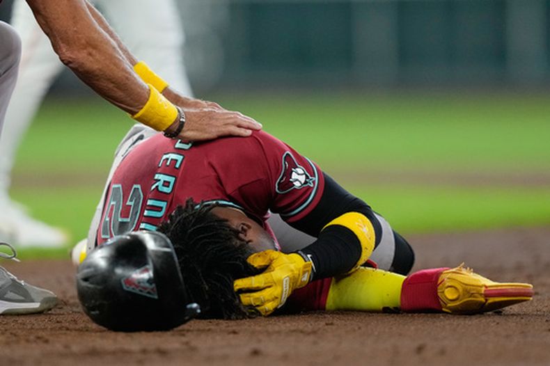 El campocorto de los Diamondbacks de Arizona, Geraldo Perdomo (2), se sujeta la cabeza tras ser golpeado por una línea bateada por su compañero Ketel Marte durante la tercera entrada de un partido de béisbol contra los Astros de Houston, el domingo 6 de septiembre de 2026, en Houston. (Foto AP/David J. Phillip)