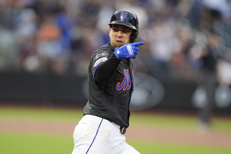 José Iglesias, de los Mets de Nueva York, gesticula hacia sus compañeros de equipo mientras corre las bases después de conectar jonrón durante la segunda entrada del juego de béisbol en contra de los Rockies de Colorado, el viernes 12 de julio de 2024, en Nueva York. (AP Foto/Frank Franklin II)