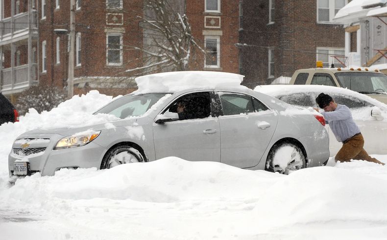 Una automovilista recibe ayuda despu&eacute;s de que su coche quedara atascado en la nieve en un estacionamiento en un edificio de apartamentos en Enfield, Connecticut, el mi&eacute;rcoles 5 de febrero de 2014. (AP Foto/Journal Inquirer, Jim Michaud)