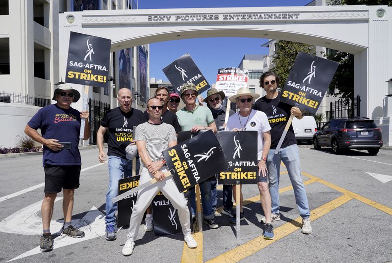 El elenco y los guionistas de Breaking Bad y Better Call Saul Juan Carlos Cantú, de izquierda a derecha, Javier Grajeda, Aaron Paul, Charles Baker, Norma Maldonad, Jesse Plemons, Peter Gould, Bryan Cranston y Matt Jones, posan en una manifestación frente a los estudios de Sony Pictures el martes 29 de agosto de 2023 en Culver City, California. Las industrias del cine y la televisión siguen paralizadas por las huelgas duales de actores y guionistas de Hollywood cuyos efectos se sienten en otros sectores de la economía de Los Ángeles. (Foto AP/Chris Pizzello)