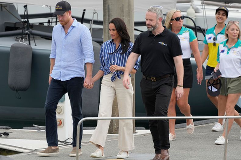 ARCHIVO - El príncipe Enrique, izquierda, y su esposa Meghan, los duques de Sussex, llegan a un muelle tras navegar por el puerto de Sídney el viernes 17 de abril de 2026. (Foto AP/Rick Rycroft, archivo)