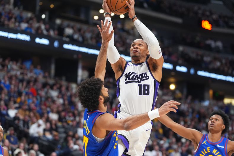 Russell Westbrook, de los Kings de Sacramento, salta para encestar entre Jamal Murray (izquierda) y Peyton Watson, de los Nuggets de Denver, en el duelo del sábado 22 de noviembre de 2025 (AP Foto/David Zalubowski)