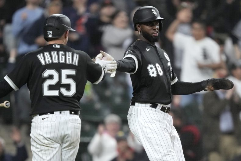 El cubano Luis Robert Jr. festeja con Andrew Vaughn, su compañero de los Medias Blancas de Chicago, durante el encuentro ante los Guardianes de Cleveland, el martes 16 de mayo de 2023 (AP Foto/Charles Rex Arbogast)