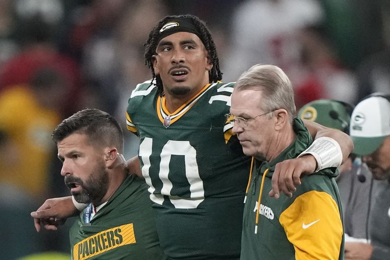 Jordan Love, quarterback de los Packers de Green Bay, abandona el terreno con ayuda tras lesionarse en el último cuarto del partido ante los Eagles de Filadelfia, el viernes 6 de septiembre de 2024, en Sao Paulo (AP Foto/Doug Benc)