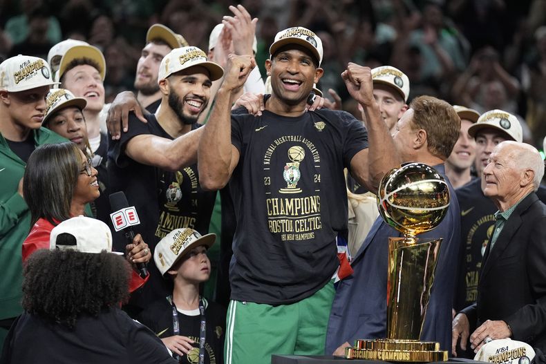 Al Horford (centro) y Jayson Tatum de los Celtics de Boston celebran tras consagrarse campeones de la NBA al vencer a los Mavericks de Dallas, el lunes 17 de junio de 2024, en Boston. (AP Foto/Charles Krupa)