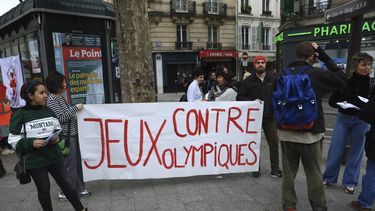 ARCHIVO - Activistas opuestos a las Olimpiadas de París de 2024 despliegan una manta que dice: Contra los Juegos Olímpicos, durante una manifestación el lunes 1 de mayo de 2023, en París. (AP Foto/Aurelien Morissard)