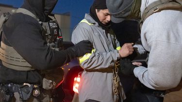 Agentes del Servicio de Control de Inmigración y Aduanas (ICE, por sus siglas en inglés) utilizan una cadena para retener con más comodidad a una personas con las esposas al frente, el lunes 27 de enero de 2025, en Silver Spring, Maryland, Estados Unidos. (AP Foto/Alex Brandon)