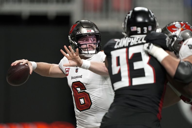 El quarterback de los Buccaneers de Tampa Bay Baker Mayfield lanza el balón bajo presión del defensive tackle de los Falcons de Atlanta Calais Campbell en el encuentro del domingo 10 de diciembre del 2023. (AP Foto/Brynn Anderson)