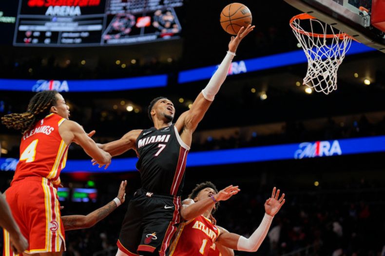 Giannis Antetokounmpo (7), del Heat de Miami, prepara una bandeja frente a los Hawks de Atlanta frente a Jalen Johnson (1) durante la segunda entrada del juego de baloncesto de la NBA, el miércoles 28 de octubre de 2026, en Atlanta. (AP Foto/Mike Stewart)