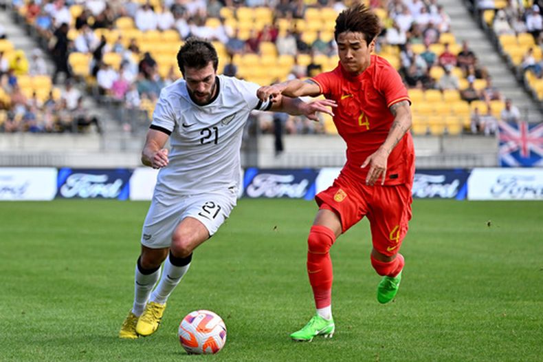 ARCHIVO - El neozelandés Tim Payne (izquierda) y el chino Shihao Wei pugnan por el balón durante un partido amistoso, el domingo 26 de marzo de 2023, en Wellington, Nueva Zelanda. (Masanori Udagawa/Photosport vía AP)