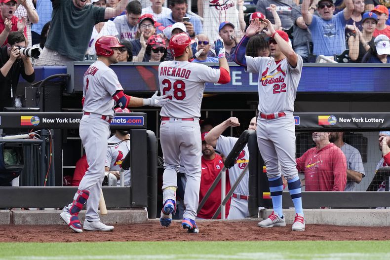Nolan Arenado de los Cardenales de San Luis celebra su jonrón con sus compañeros Dylan Carlson y Jack Flaherty en la novena entrada del juego ante los Mets de Nueva York el domingo 18 de junio del 2023. (AP Foto/Seth Wenig)