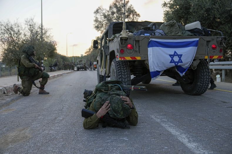 Un soldado israelí piensa erróneamente que se activó una alarma de ataque aéreo y se echa al suelo para cubrirse, en el kibutz Beeri, en Israel, el miércoles 11 de octubre de 2023. (AP Foto/Ohad Zwigenberg)