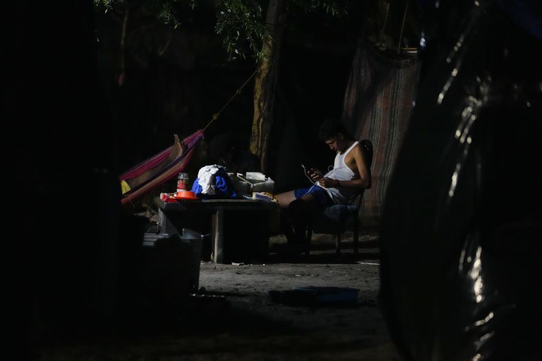 Un hombre aguarda en un campamento en la frontera entre Texas y México, en la madrugada del viernes 12 de mayo de 2023, en Matamoros, México. (AP Foto/Julio Cortez)