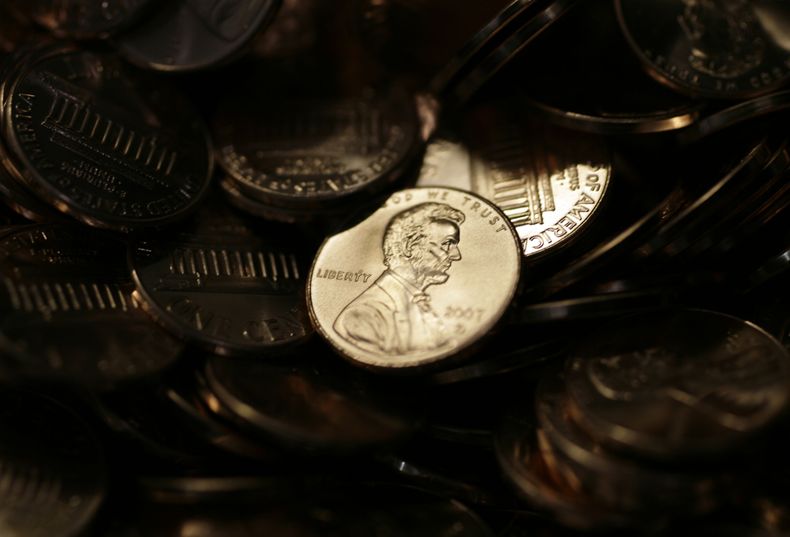 ARCHIVO - Un centavo de dólar iluminado en medio de otras monedas de centavo en la Casa de Moneda de EEUU en Denver el miércoles 15 de agosto de 2007. (AP Foto/David Zalubowski, Archivo)