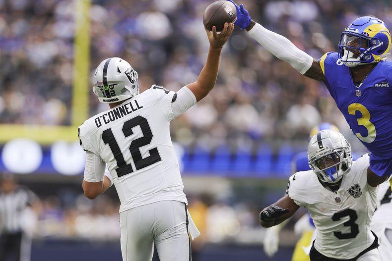 El quarterback de los Raiders de Las Vegas, Aidan OConnell (12), intenta lanzar un pase mientras el safety de los Rams de Los Ángeles, Kamren Curl (3), salta para defenderse durante la primera mitad de un partido de fútbol americano de la NFL, el domingo 20 de octubre de 2024, en Inglewood, California (AP Foto/Ryan Sun)