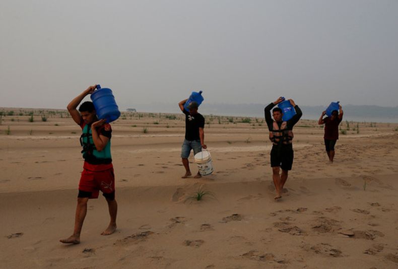 Residentes llevan agua desde Humaita hacia la comunidad de Paraizinho, a lo largo de un tramo seco del río Madeira, un afluente del río Amazonas, en medio de una sequía, el 8 de septiembre de 2024, en el estado de Amazonas, Brasil. (AP Foto/Edmar Barros, Archivo)