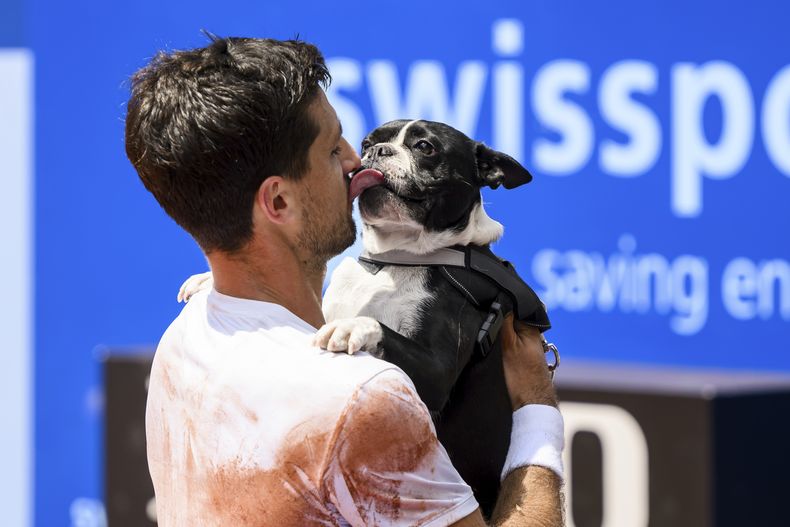 El campeón Pedro Cachín besa a su perro Tango tras derrotar a Albert Ramos-Viñolas en la final del Abierto de Suiza en Gstaad, el domingo 23 de julio de 2023. (Jean-Christophe Bott/Keystone vía AP)