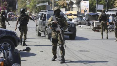 Elementos de la Unidad de Seguridad General del Palacio Nacional de Haití establece un perímetro para retomar el control de una de las tres delegaciones de policía que fueron tomadas por pandillas, en el centro de Puerto Príncipe, Haití, el sábado 9 de marzo de 2024. (AP Foto/Odelyn Joseph)