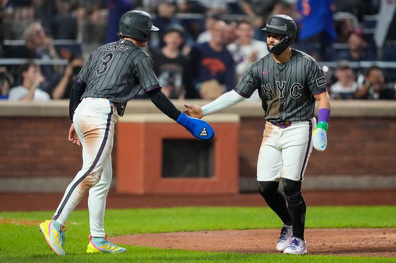 Carson Benge y Bo Bichette de los Mets de Nueva York celebran tras anotar en el wild pitch en la tercera entrada del pitcher de los Yankees de Nueva York Carlos Rodon el sábado 16 de mayo del 2026. (AP Foto/Yuki Iwamura)