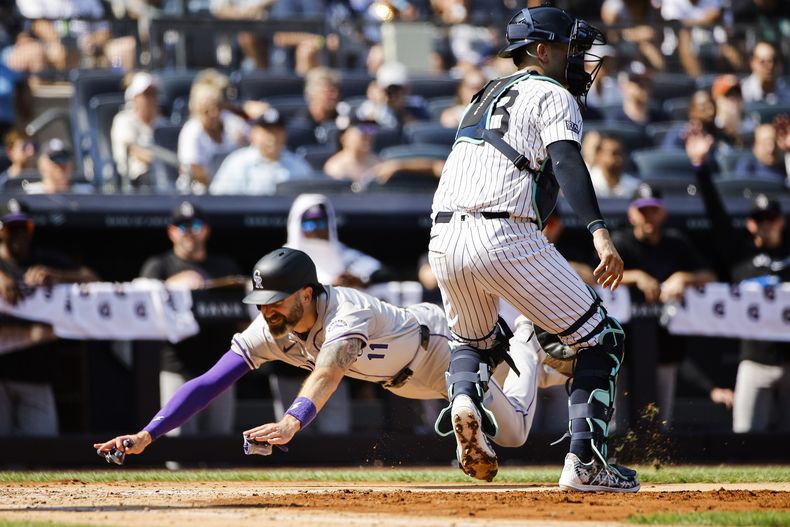 Jake Cave (11), de los Rockies de Colorado, anota una carrera durante la tercera entrada contra los Yankees de Nueva York, el sábado 24 de agosto de 2024, en Nueva York. (AP Foto/Eduardo Muñoz Álvarez)