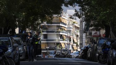 Agentes de policía vigilan cerca de la entrada de un edificio tras una explosión -que la policía cree causada por un artefacto improvisado- en la que murió un hombre y una mujer resultó gravemente herida, en Atenas, el viernes 1 de noviembre de 2024. (AP Foto/Petros Giannakouris)