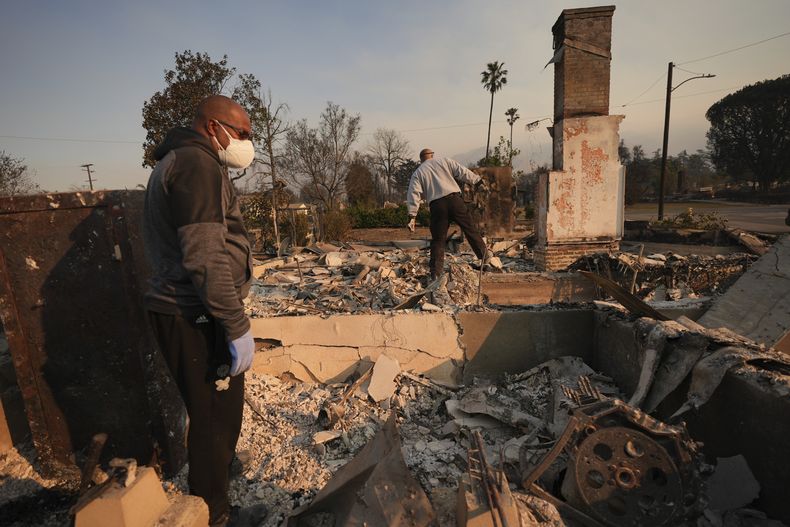 Kenneth Snowden (izquierda) revisa los daños causados por el incendio Eaton en su propiedad, junto a su hermano Ronnie, el 10 de enero de 2025, en Altadena, California. (AP Foto/Jae C. Hong)