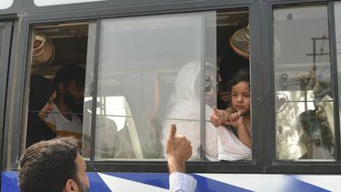 Un familiar indio hace un gesto con el pulgar hacia arriba a una familia paquistaní que abandona el país en un bus, en Attari-Wagah, en la frontera entre India y Pakistán, cerca de Amritsar, India, el 30 de abril de 2025. (AP Foto/Prabhjot Gill)