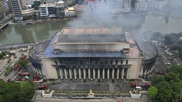 El humo sale de la Oficina Postal Central de Manila, aún humeante tras un incendio el lunes 22 de 2023 en Manila, Filipinas. Un enorme incendio se extendió por el edificio histórico de correos durante la noche. (AP Foto/Aaron Favila)