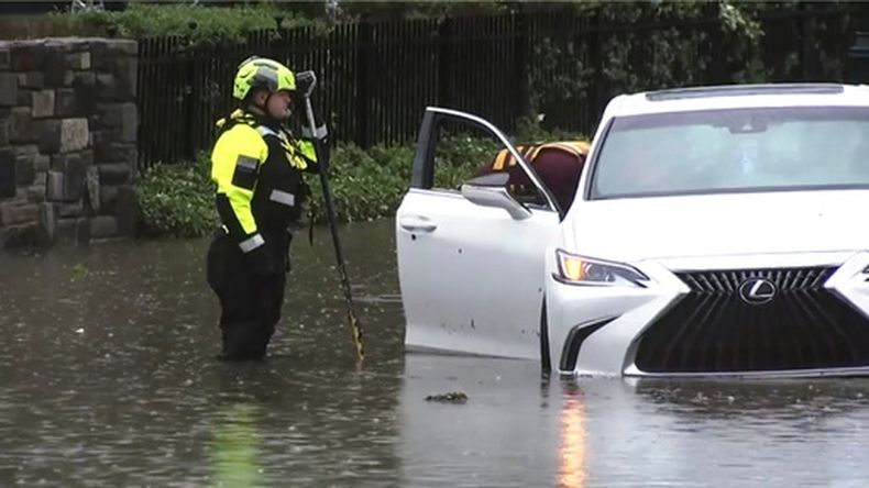 Esta imagen tomada de un vídeo muestra a las autoridades inspeccionando un coche en una calle inundada de Filadelfia el domingo 12 de julio de 2026, después de una serie de tormentas. (WPVI-TV/6ABC vía AP)