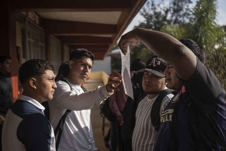 Varios estudiantes revisan los horarios del primer día de clases en la escuela Normal Rural Raúl Isidro Burgos de Ayotzinapa, en el estado de Guerrero, México, el lunes 26 de agosto de 2024. (AP Foto/Félix Márquez)