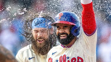 Derek Hill, derecha, de los Filis de Filadelfia, celebra con Brandon Marsh después de batear el sencillo decisivo en la 12da entrada del juego de béisbol de Grandes Ligas ante los Azulejos de Toronto, el domingo 9 de agosto de 2026, en Filadelfia. (AP Foto/Laurence Kesterson)