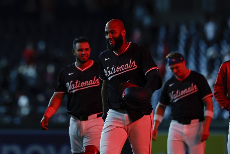 El dominicano Amed Rosario festeja con sus compañeros de los Nacionales de Washington tras batear el hit decisivo ante los Bravos de Atlanta, el jueves 22 de mayo de 2025 (AP Foto/Terrance Williams)