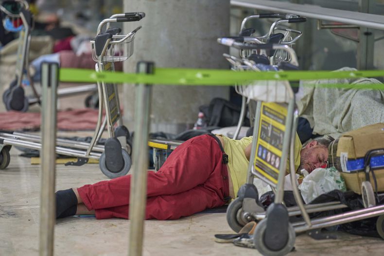 Una persona duerme en el piso de la Terminal 4 del Aeropuerto Internacional Adolfo Suárez Madrid-Barajas, en Madrid, España, el jueves 15 de mayo de 2025. (AP Foto/Manu Fernandez)